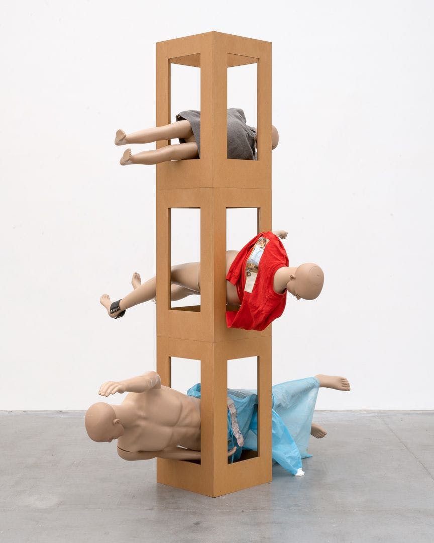 An untitled MDF tower, mannequins, leather, plastic tape, hospital gown, jumper with transfer print, and jumper sculpture by Isa Genzken, dated 2018.